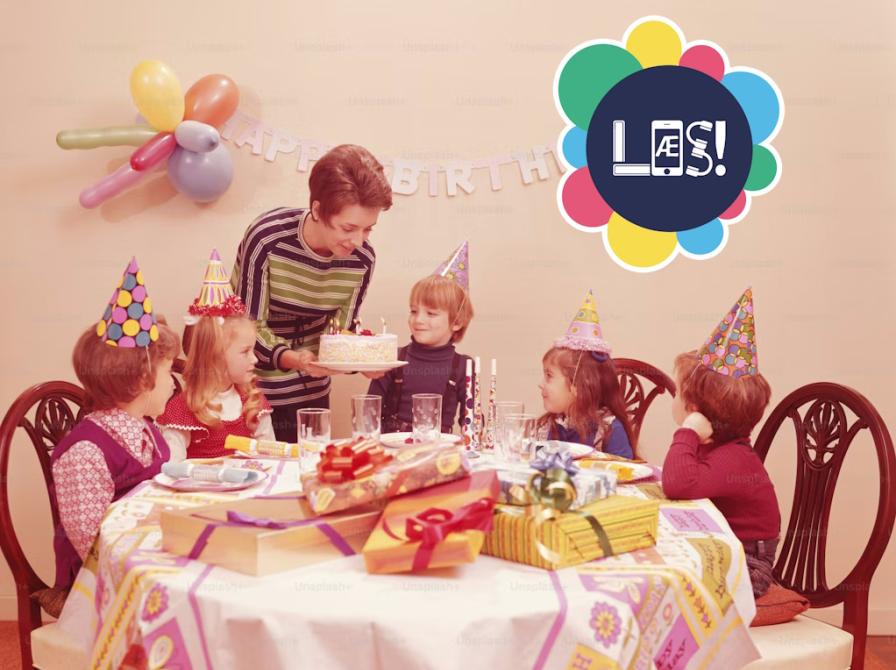 Fødselsdagsbord der er dækket op. Fem børn ser forventningsfuldt på den lagkage, som mor bærer ind.